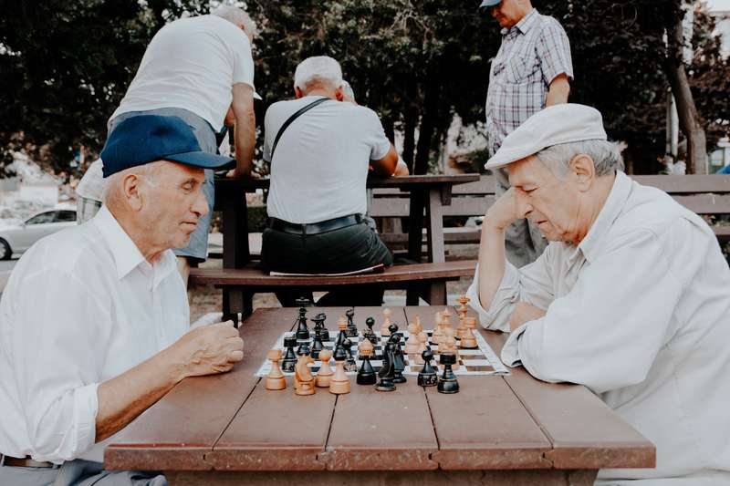 Elderly Men Engaged In Chess Game